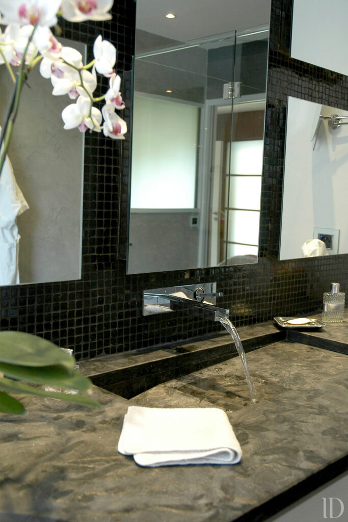 Création d'une salle de bain parental ouverte sur la chambre avec grande douche à l'italienne et banc de douche intégré. Vasque incrusté dans le plan vasque et jeu de miroir