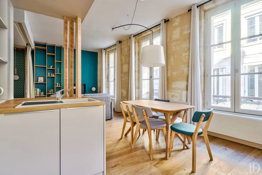 Réalisation d'une cuisine dans un appartement rénové entièrement sur Bordeaux. Cuisine bois et façade blanc crème ouverte sur le séjour